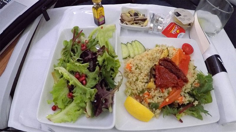 Healthy salad greens and pomegranate with a mediterranean couscous served aboard flight AA72.