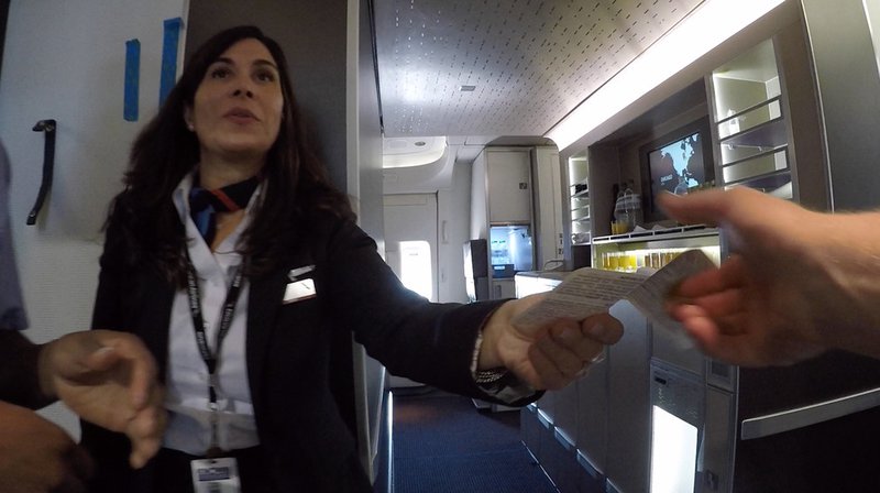 A friendly greeting from cabin crew aboard American Airlines flight AA72. The snack galley, visible on the right of this image, comes in handy on a long haul flight.